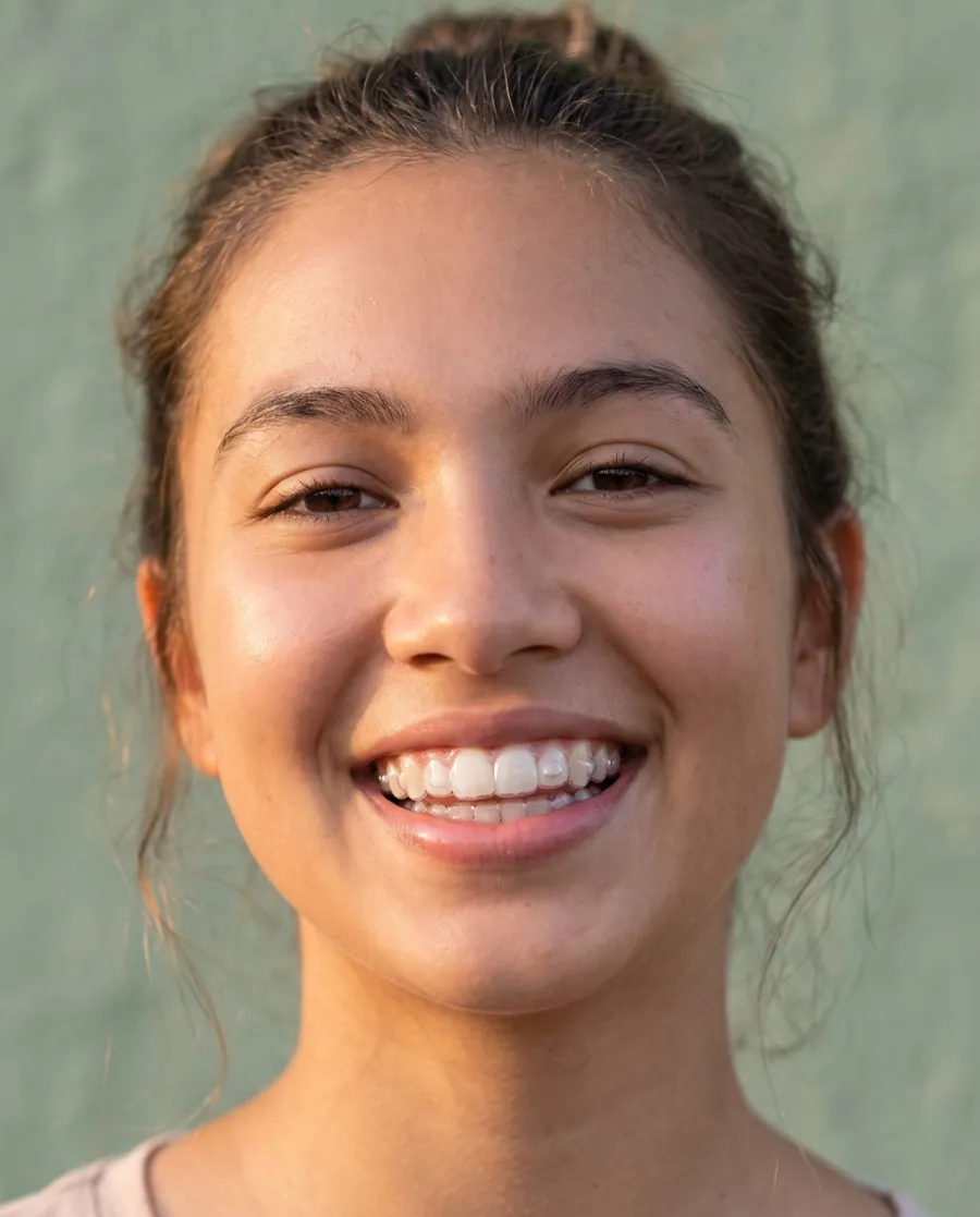 A teenager smiling with clear aligners